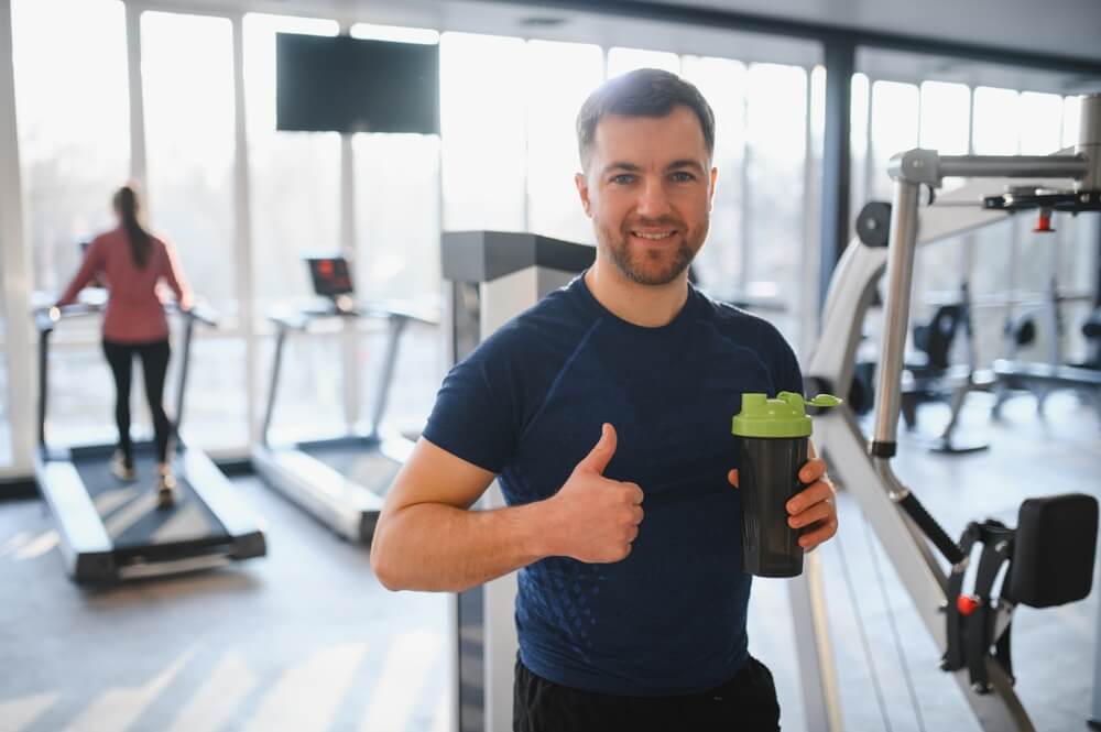 Person,Enjoying,Workout,And,Holding,Bottle,With,Protein,Shake,,Showing